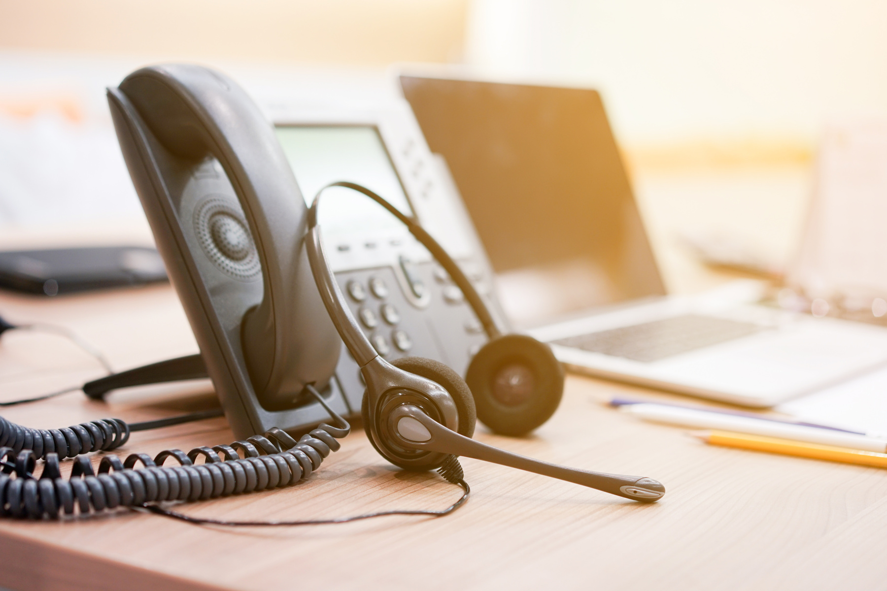 close up focus on call center headset device at telephone VOIP system at office desk for hotline telemarketing concept with vintage color filter